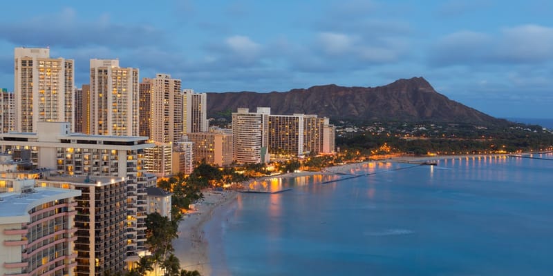 Waikīkī Beach skyline at dusk with Diamond Head behind it