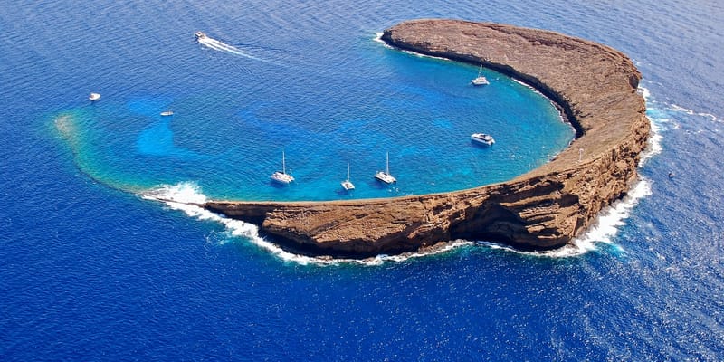 Aerial view of Molokini Crater with snorkel boats anchored in its bay